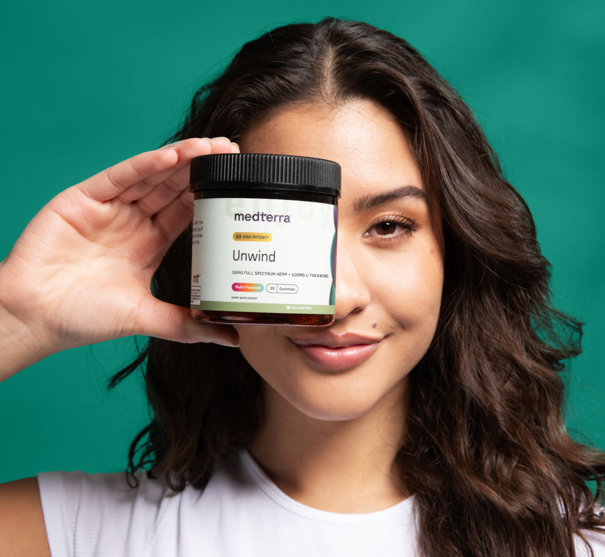 Woman Holding UnWind Gummies in Hand